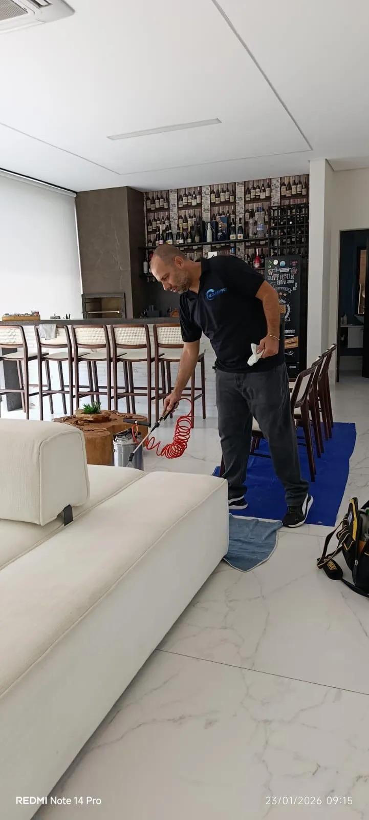 Técnico da Xclean90 aplicando impermeabilizante em sofá